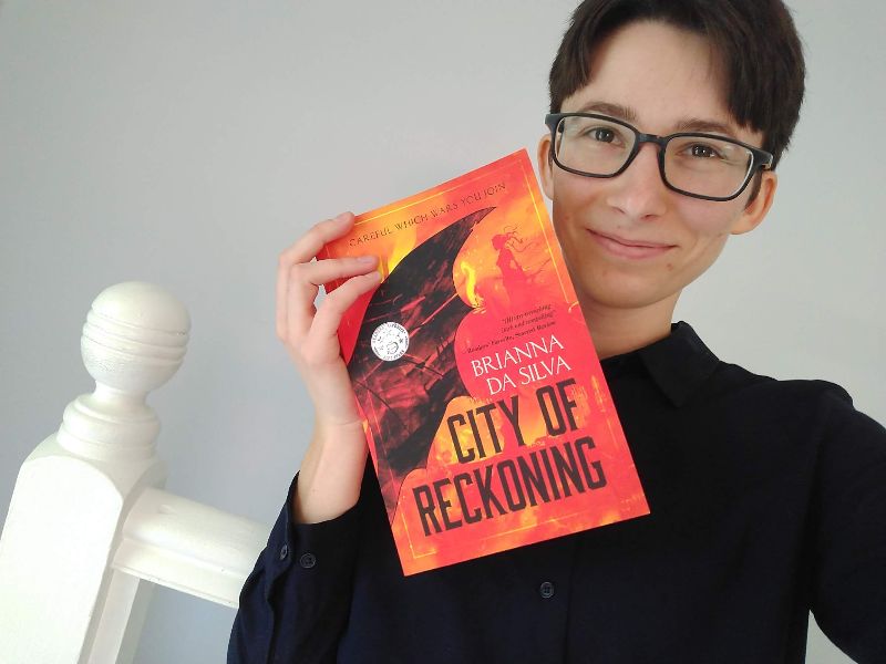 Brianna da Silva posing with her novel City of Reckoning